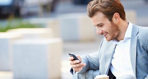 Happy businessman looking at smartphone